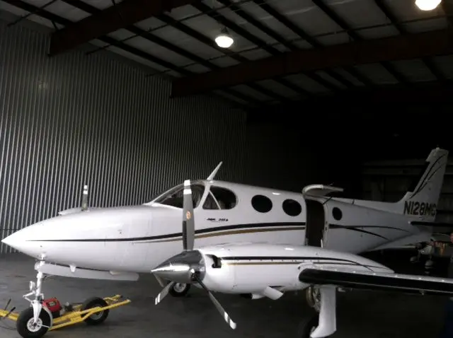 Twin-engine aircraft with tinted windows in a hangar