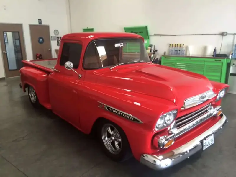 Restored red 1950s Chevrolet pickup in the tint bay