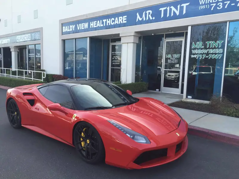 Red Ferrari 488 with tinted windows parked outside Mr. Tint