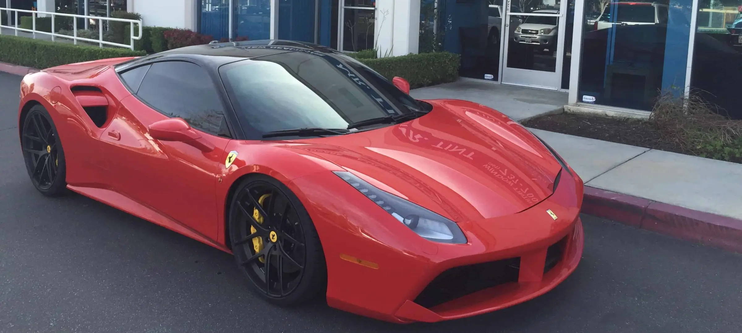 Red Ferrari 488 with freshly tinted windows parked outside the Mr. Tint shop in Norco