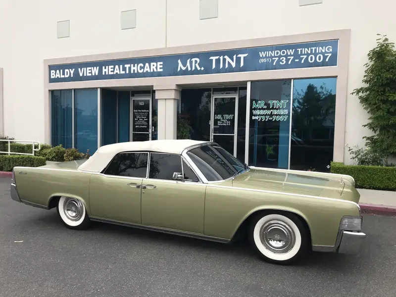 Classic Lincoln Continental convertible outside the shop