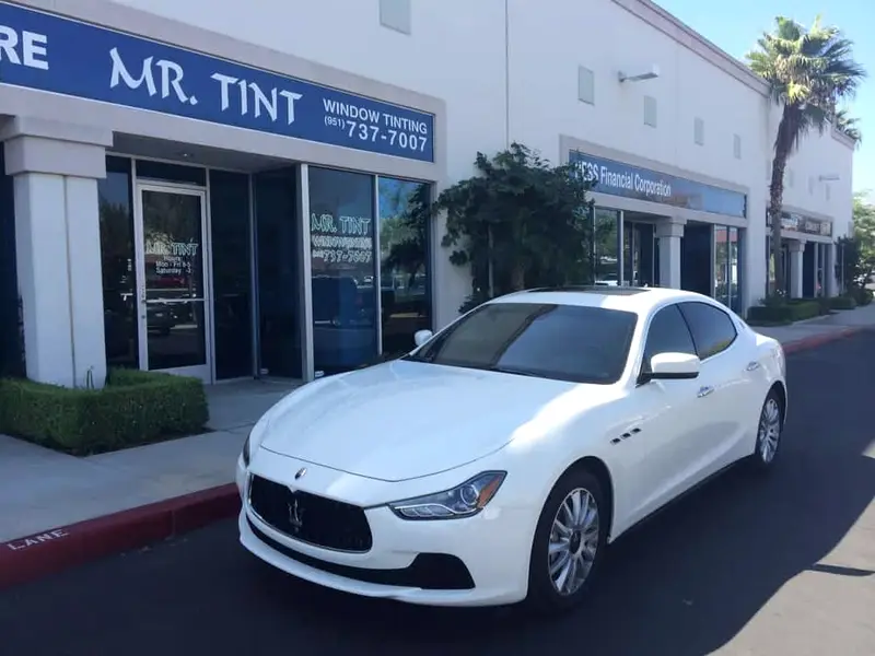 White Maserati Ghibli with tinted windows outside the shop