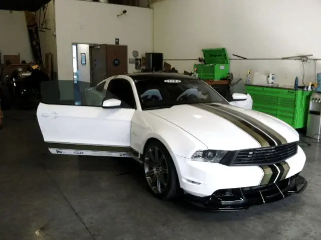 White Ford Mustang with racing stripes in the tint bay
